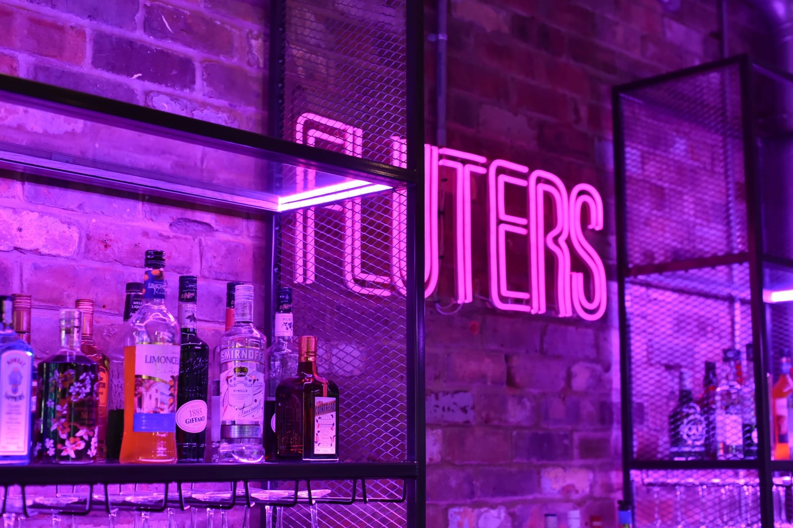 The bar at 1 Mill Street, Leamington Spa: bottle shelves and taps under neon lights