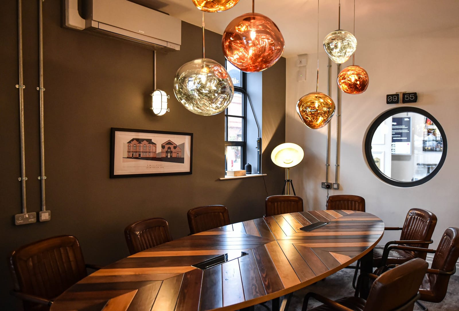The Boardroom at 1 Mill Street: a long table under copper pendant lights with a large screen