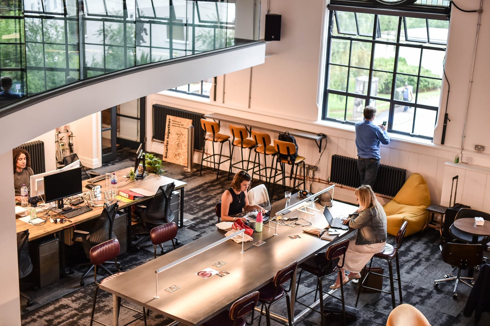 The coworking floor seen from above, with desks lined up by the windows