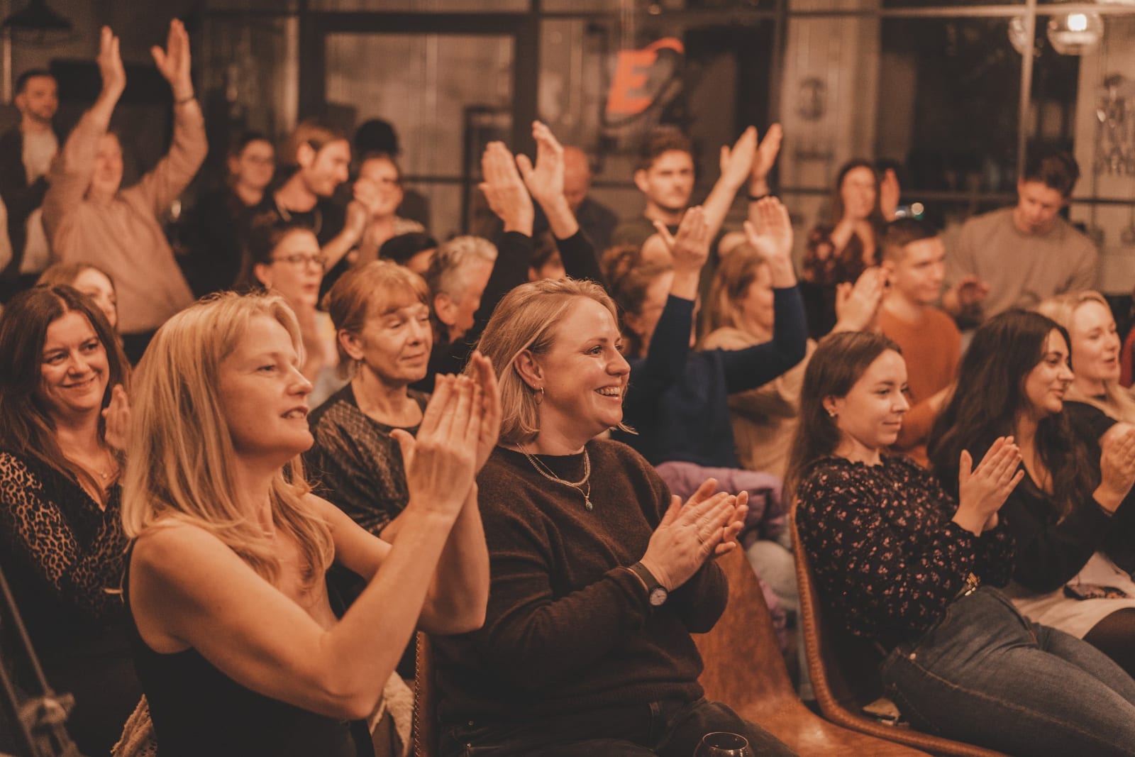 An audience applauding at an event in the hall