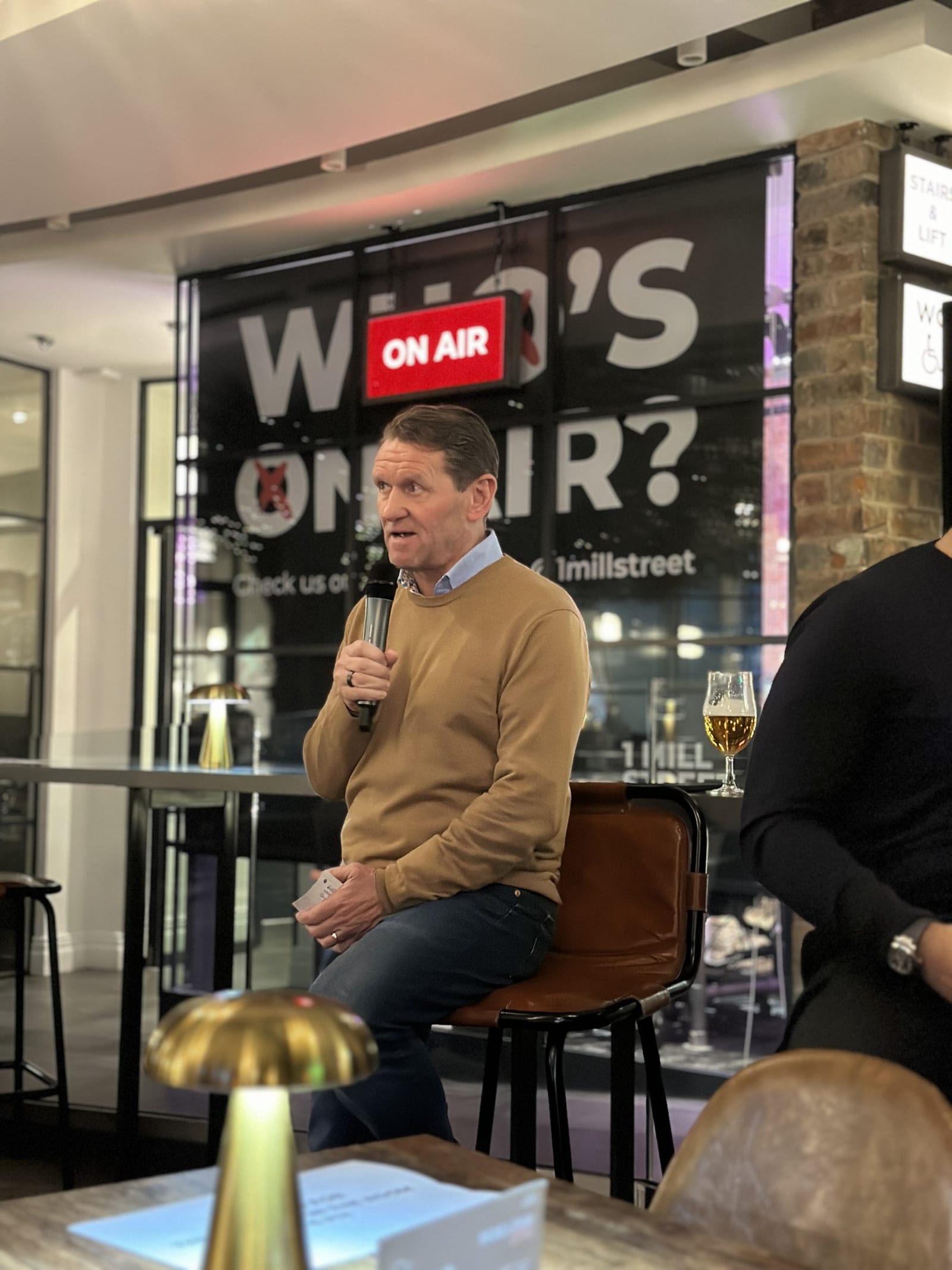A fireside chat on stage in the event space at 1 Mill Street
