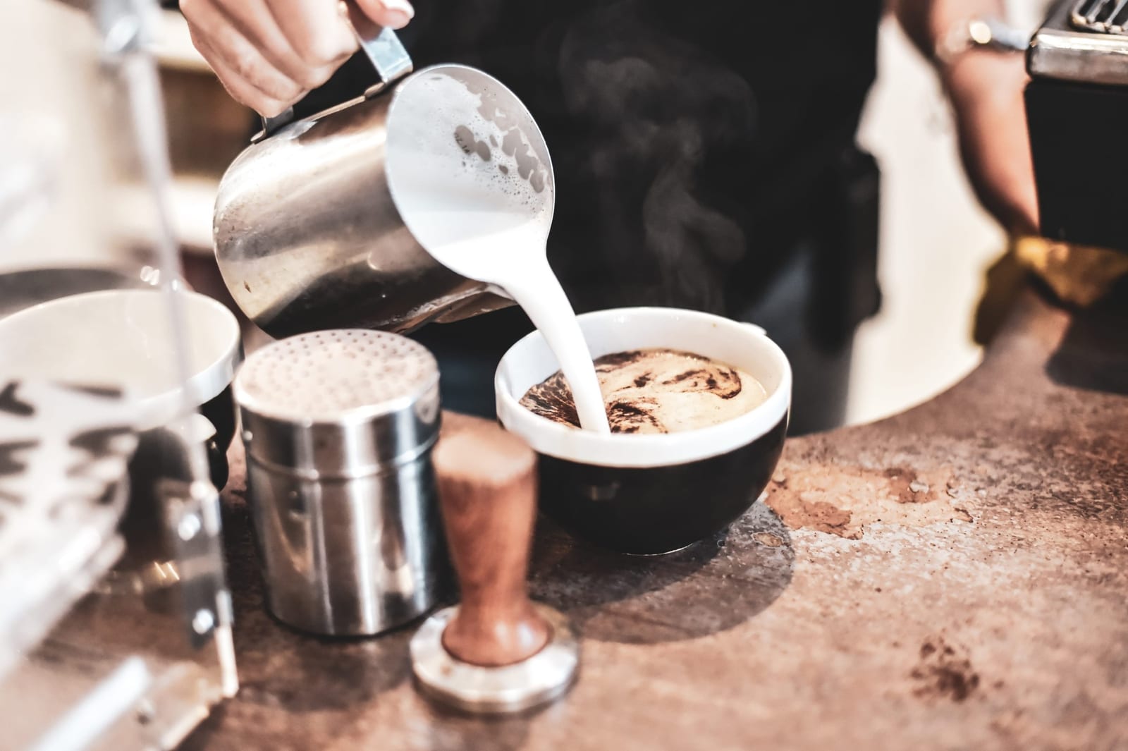 A barista pouring latte art at Forrest Coffee House