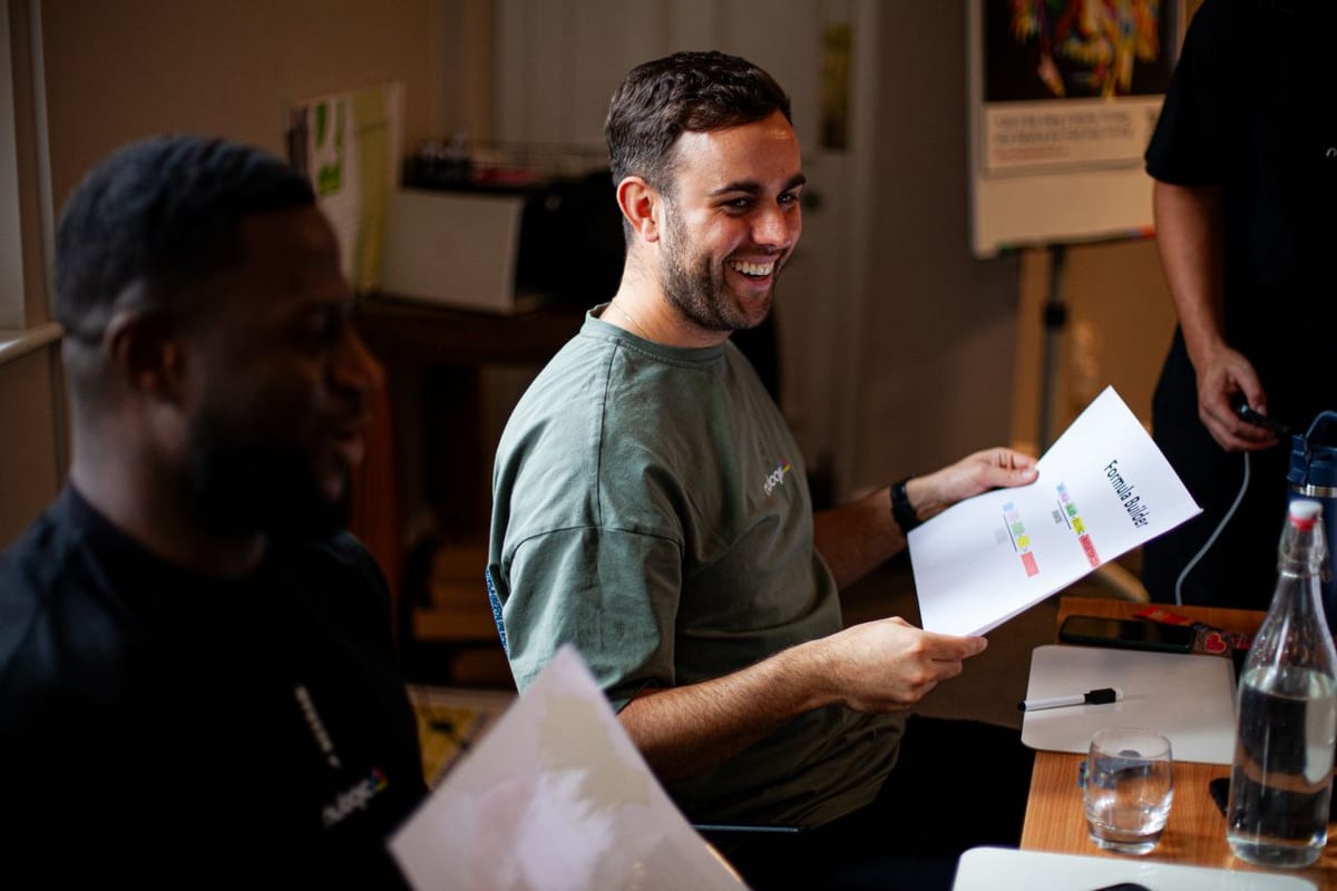 Dave from Nulogic laughing at a team workshop, holding a Formula Builder handout