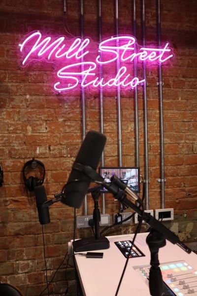 A podcast microphone under neon light in the studio